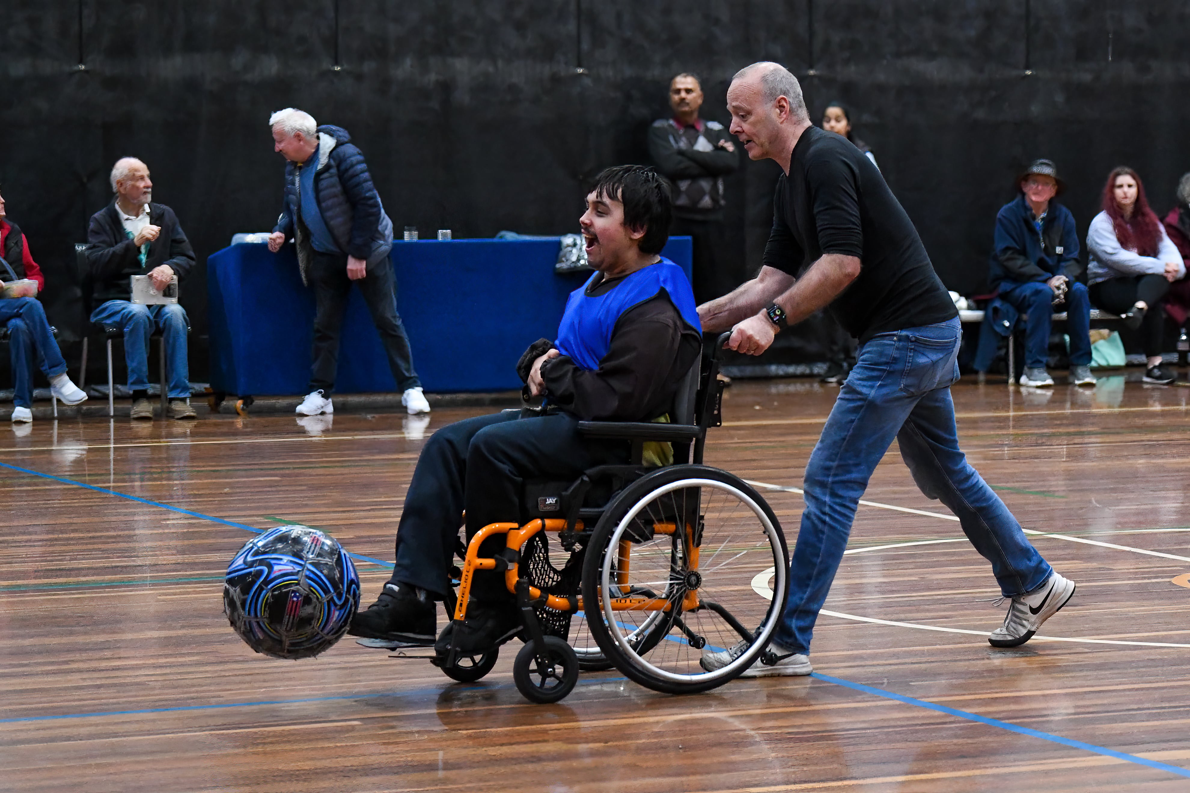 Volunteer pushing wheelchair football player