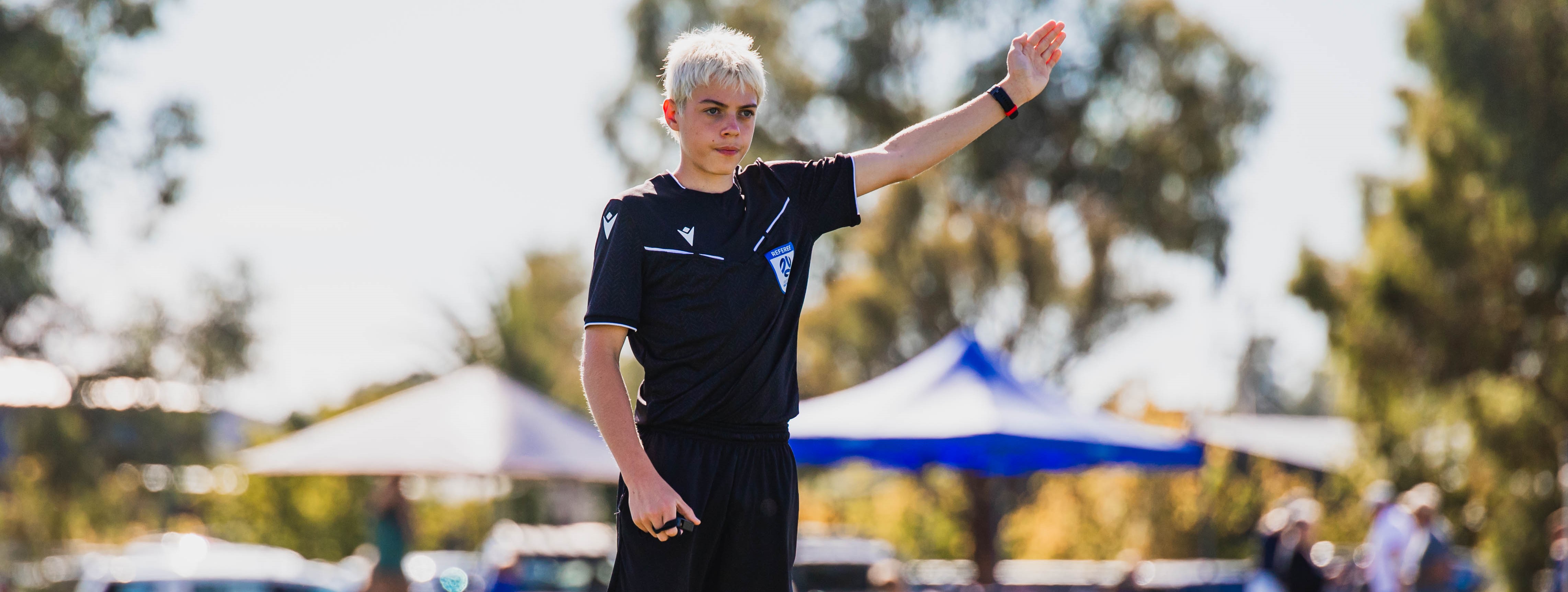 Young Referee match officiating in the day at a social event