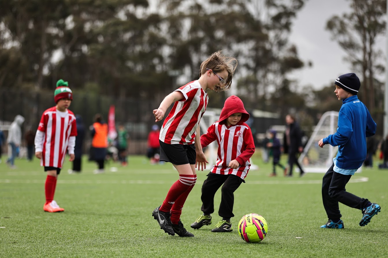 three kids playing football match