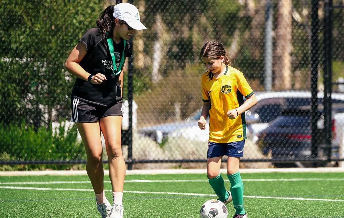 Woman and girl playing casual football