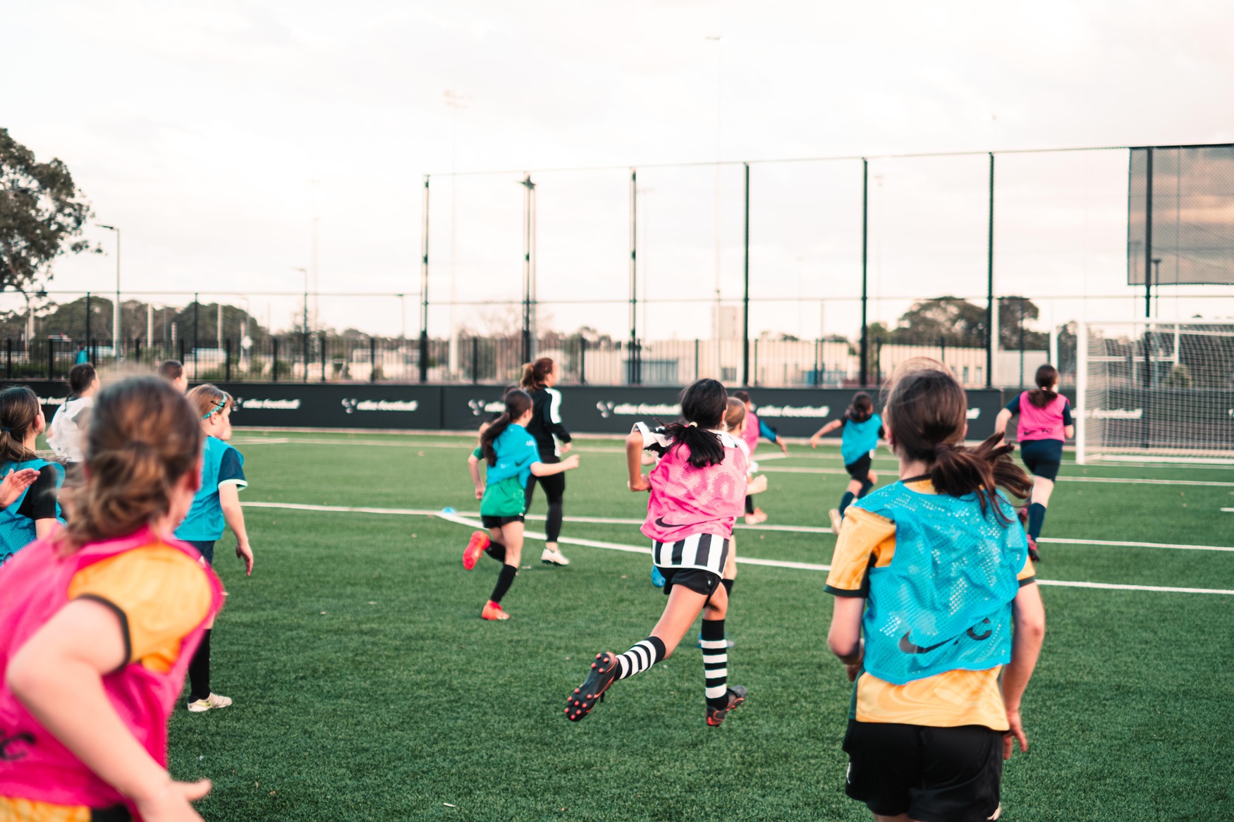 Girls running on the Nike pitch at a Nike Rock Up & Play session