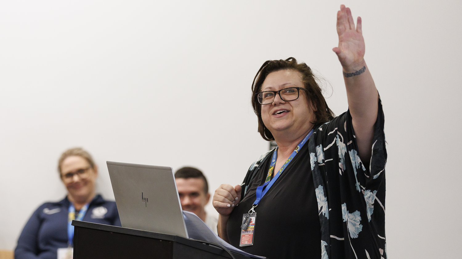 Woman with laptop presenting and pointing up