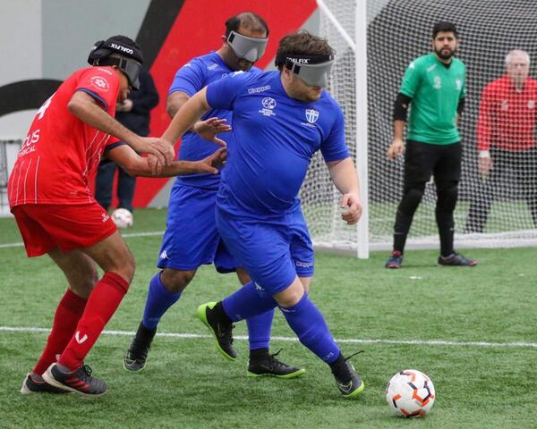 South Melbourne player running with the ball, Olympic FC and SMFC Player in background.